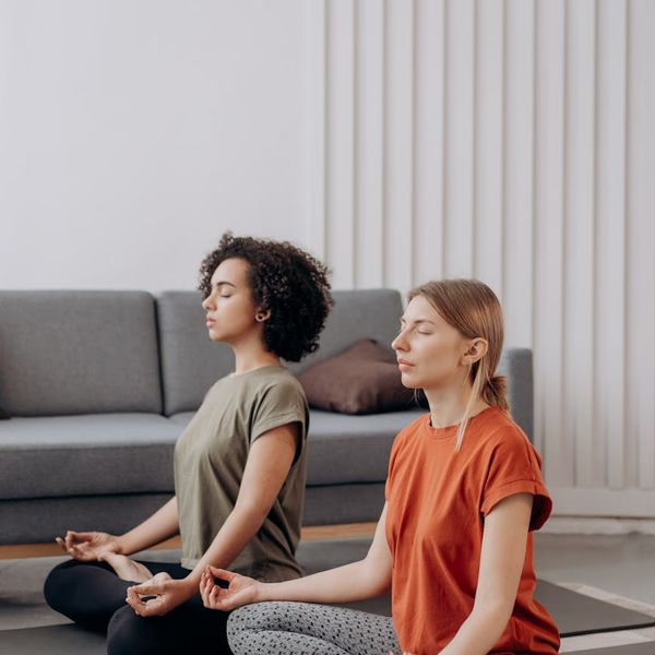 Woman in a calm yoga pose in a bright, peaceful room.